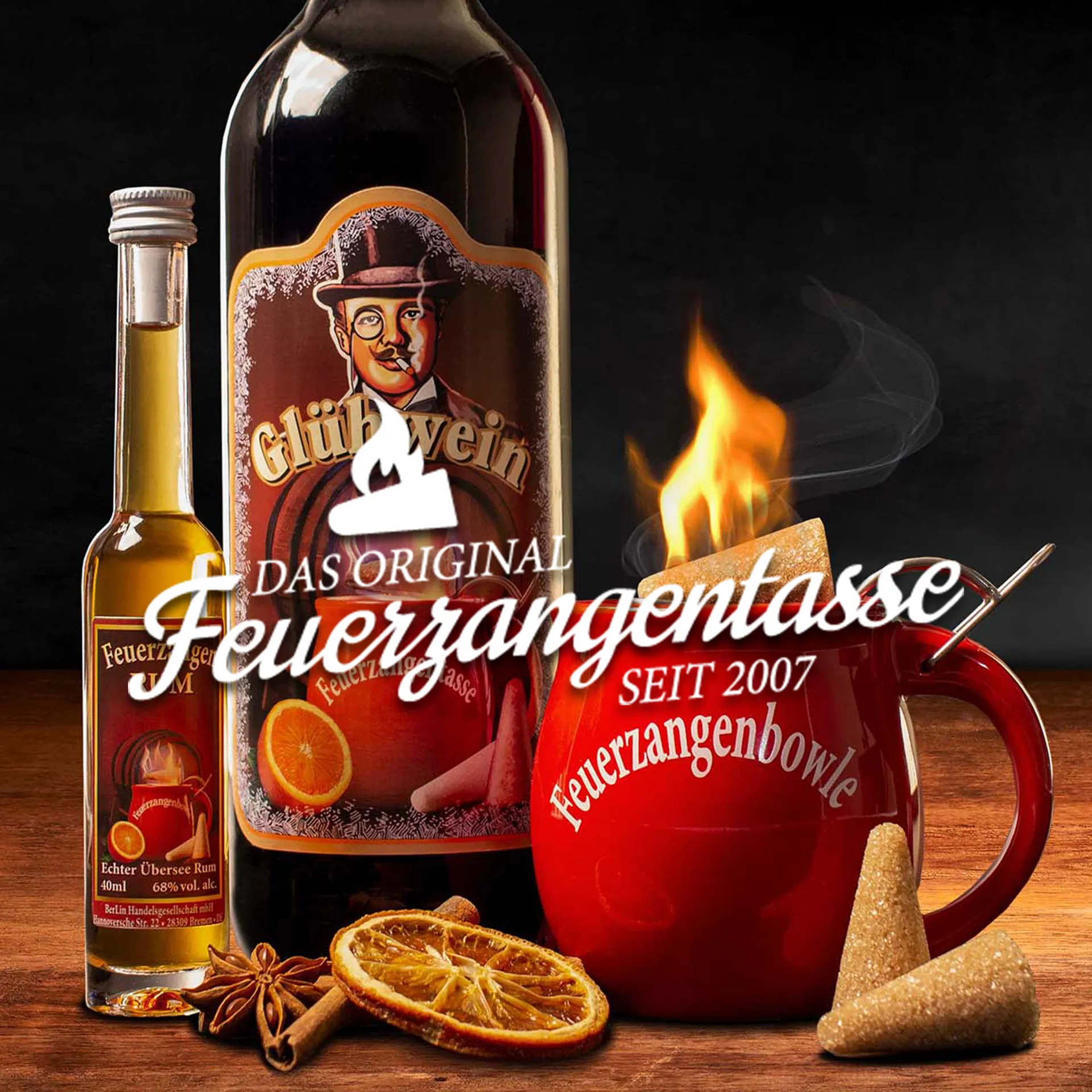 Zu sehen ist eine Feuerzangenbowle Tasse mit brennendem Zuckerhut, eine Flasche Feuerzangentassen-Glühwein und Rum. Das Logo von Feuerzangentasse ist mittig eingeblendet